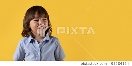 Cute happy little boy looking aside and laughing, enjoying great news, orange background with empty space, panorama Cute happy little boy looking aside and laughing, enjoying great news, orange background with empty space, panorama 95384124