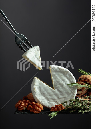 Brie cheese and fork with triangle piece. 95384162