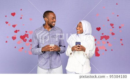 Happy Muslim Black Couple Texting On Smartphones, Purple Background, Collage 95384180