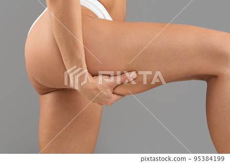 Closeup Shot Of Young Slim Woman Pulling Skin On Her Thigh With Hand Closeup Shot Of Young Slim Woman Pulling Skin On Her Thigh With Hand 95384199