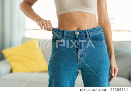 Unrecognizable Fit Lady Posing After Successful Slimming Wearing Jeans Indoors Unrecognizable Fit Lady Posing After Successful Slimming Wearing Jeans Indoors 95384334