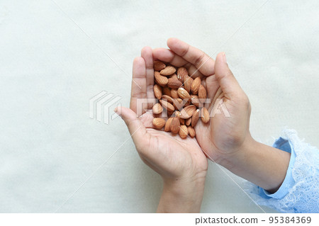 top view of women hand holding almond nuts top view of women hand holding almond nuts 95384369