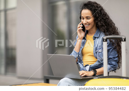 Attractive woman traveller waiting for her flight, having phone call Attractive woman traveller waiting for her flight, having phone call 95384482