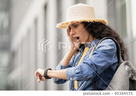 Stressed young woman tourist checking time, got late Stressed young woman tourist checking time, got late 95384535