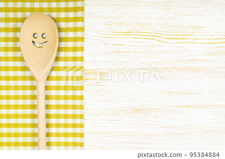 Kitchen mockup. Wooden spoon with smile on white wooden background. Food background with copy space Kitchen mockup. Wooden spoon with smile on white wooden background. Food background with copy space 95384884