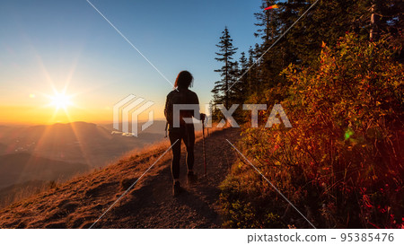 Adventurous Woman Hiking in Canadian Landscape with Fall Colors during sunny sunset. 95385476