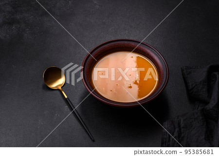 Delicious hot pumpkin and carrot soup puree with spices and herbs 95385681