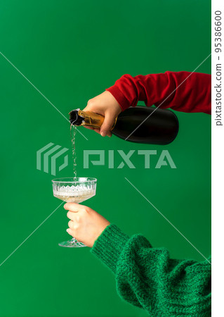 Festive background concept for Christmas party, hand pouring champagne, wine into glass 95386600