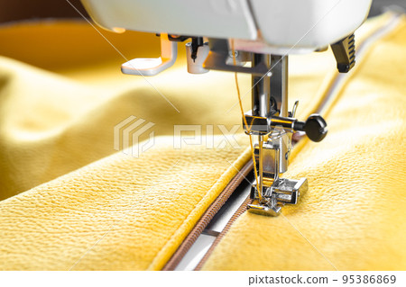 Modern sewing machine and yellow fabric. Sewing process, handmade, hobby, DIY, business, repair Modern sewing machine and yellow fabric. Sewing process, handmade, hobby, DIY, business, repair 95386869
