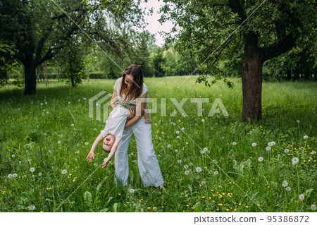 Young woman mom and son play in nature, spend time together and have fun Young woman mom and son play in nature, spend time together and have fun 95386872