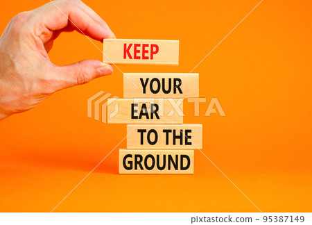 Keep your ear to the ground symbol. Concept words Keep your ear on the ground on wooden blocks. Businessman hand. Beautiful orange background. Business keep your ear on the ground concept. Copy space. Keep your ear to the ground symbol. Concept words Keep your ear on the ground on wooden blocks. Businessman hand. Beautiful orange background. Business keep your ear on the ground concept. Copy space. 95387149