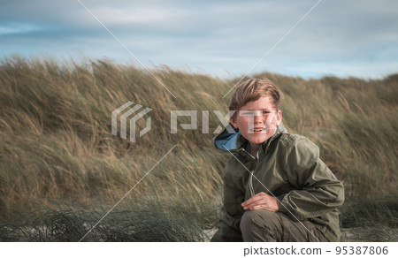 Little blonde kid boy in the field of grass. One color of boys hair and grass. Kids and nature. Child discover planet. Part of the planet. Portrait of freckled boy in green clothes. Face of smart kid Little blonde kid boy in the field of grass. One color of boys hair and grass. Kids and nature. Child discover planet. Part of the planet. Portrait of freckled boy in green clothes. Face of smart kid 95387806