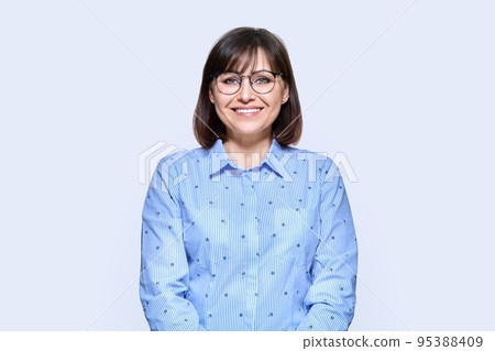 Middle aged smiling business woman over light background 95388409