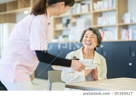 Senior woman long-term care image meal serving 95388427