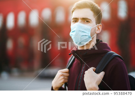 Portrait of men in protective sterile medical mask on her face on the street city. pandemic in quarantine city. 95388470