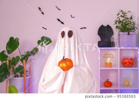 Funny Halloween concept. A big Ghost is holding an 95388503