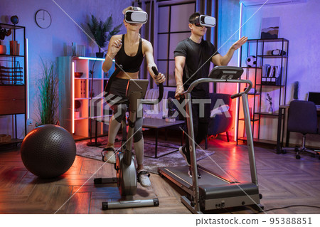 Home fitness workout sporty people caucasian woman and asian man training on exercise machines 95388851