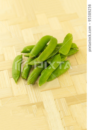 handful of fresh peas in pods on a wooden background 95389256