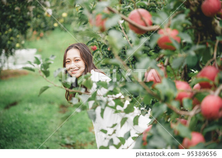 A woman in a white dress with an apple 95389656