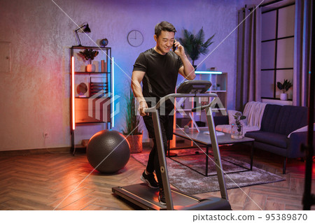 Attractive young sports asian man using smartphone working out, running 95389870
