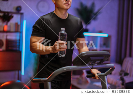 Cropped view of attractive young sports asian man with water bottle working out Cropped view of attractive young sports asian man with water bottle working out 95389888