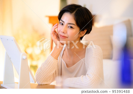 A woman who uses beauty essence and lotion before going to bed 95391488
