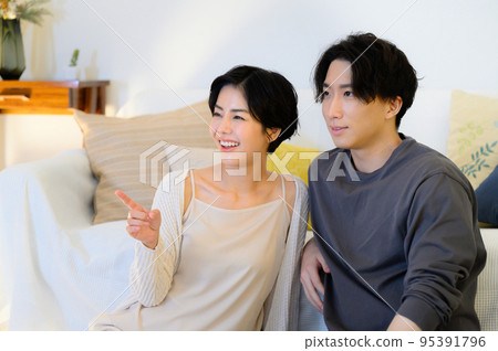 A couple relaxing at night watching movies, TV, etc. A couple relaxing at night watching movies, TV, etc. 95391796
