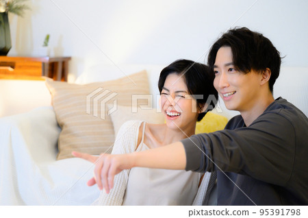 A couple relaxing at night watching movies, TV, etc. 95391798