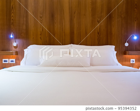Clean Bedding sheets and pillow on natural wall room background. Clean Bedding sheets and pillow on natural wall room background. 95394352