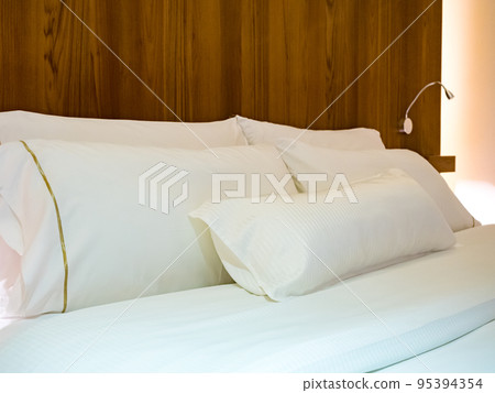 Clean Bedding sheets and pillow on natural wall room background. Clean Bedding sheets and pillow on natural wall room background. 95394354