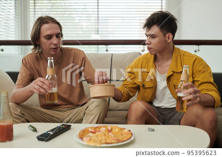 Best friends drinking beer, eating potato chips and pizz when discussing news Best friends drinking beer, eating potato chips and pizz when discussing news 95395623