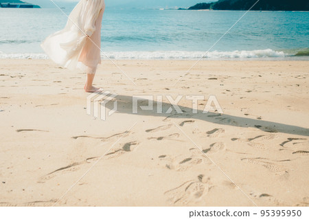 Photo of a woman standing by the beach 95395950
