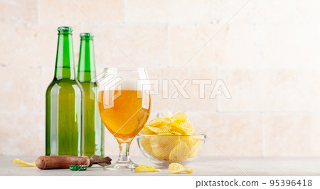 Beer glass, beer bottles and potato chips Beer glass, beer bottles and potato chips 95396418