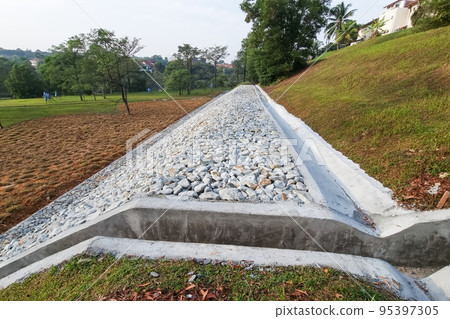 Completed slope retention construction design with rocks and mesh to manage landslide 95397305