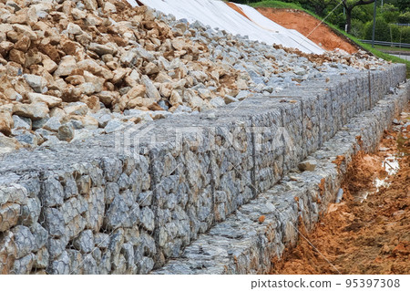 Series of close-up slope retention construction design with rocks and mesh to manage landslide Series of close-up slope retention construction design with rocks and mesh to manage landslide 95397308