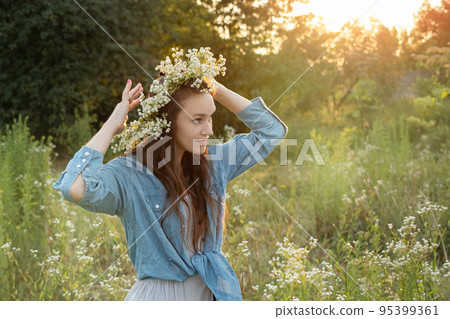 Beautiful girl  walking on field on summer with wildflowers. 95399361