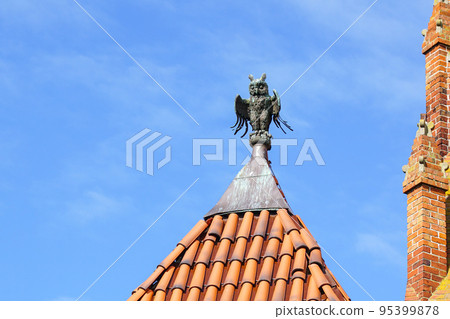 A decorative element of the top of the clay tile roof of Malbork Castle in the shape of an owl 95399878