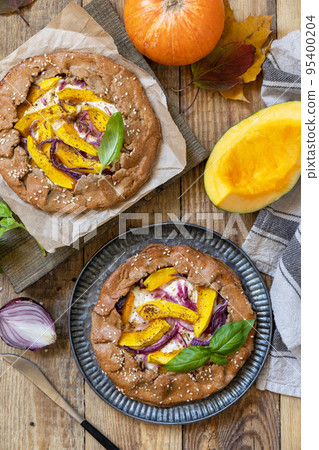 Homemade galette pie or crostata with pumpkin and ricotta cheese on rustic  background. Thanksgiving day food. View from above. 95400204