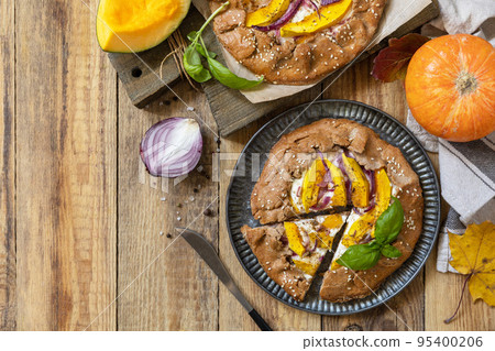 Homemade galette pie or crostata with pumpkin and ricotta cheese on rustic  background. Thanksgiving day food. View from above. Copy space. 95400206