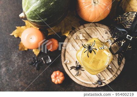 Halloween pumpkin iced cocktails in glass jars on a stone table. Party cocktails. View from above. Copy space. Toned image. Halloween pumpkin iced cocktails in glass jars on a stone table. Party cocktails. View from above. Copy space. Toned image. 95400219