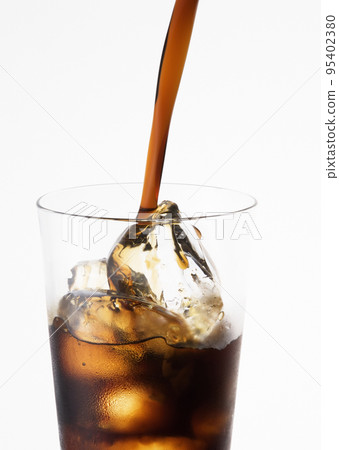 Ice cube droped in cola glass Ice cube droped in cola glass 95402380