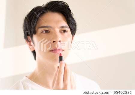 Young man doing self-makeup Men's beauty image Young man doing self-makeup Men's beauty image 95402885