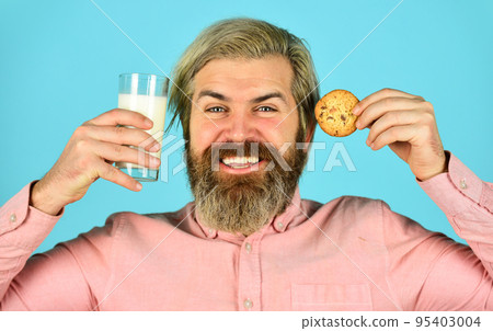 Bearded man drink milk with cookies. Leave it for Santa. Breakfast or lunch. Milk and sweet cookies. Happy hipster eat cookie dessert. Delicious treats. Homemade is best. Recipe for baking cookies 95403004