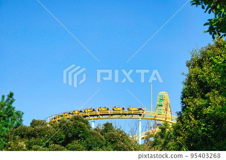 過山車的黃色軌道在藍天中閃耀的風景 95403268