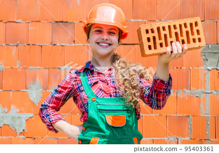 future engineer. happy kid use brick for renovation repairing. building construction site. child architect worker. labor day concept. childhood development. teenager girl assistant future engineer. happy kid use brick for renovation repairing. building construction site. child architect worker. labor day concept. childhood development. teenager girl assistant 95403361