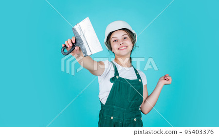 cheerful child laborer using building uniform and plastering spatula, labor day cheerful child laborer using building uniform and plastering spatula, labor day 95403376