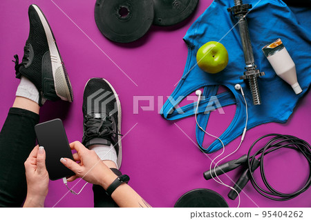 Young woman with mobile phone and sport equipment on color background flat lay top view. Fitness concept 95404262