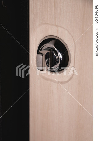 Close up of stylish silver chrome door handle on modern interior door. Stylish light brown door with frosted glass inserts. Concept of catalog of door handles for furniture store 95404696