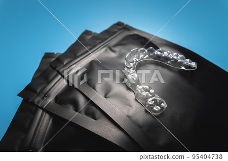 corrective aligners for the beauty of teeth lie on a black package. special storage bags. dentistry and health care 95404738