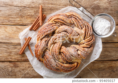 Kringle tasty Estonian, Czech and Skandinavian dessert with cinnamon closeup on the paper. Horizontal top view 95405017